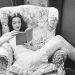 donna che legge un trama interessante di un libro seduta in poltrona